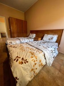 1 Schlafzimmer mit 2 Betten mit einer Bettdecke in der Unterkunft Olympia in Kfardebian