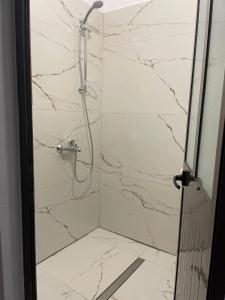 baño con ducha de mármol blanco en Borsh Beach Apartments - BBA, en Borsh