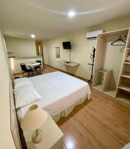 um quarto de hotel com uma cama, uma mesa e cadeiras em Harbor Self Buriti Hotel em Campo Grande