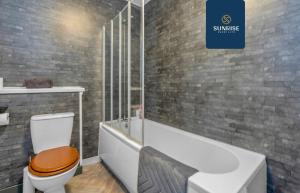 a bathroom with a toilet and a bath tub at THE DENS, 3 Rooms, 4 Beds, 2 Bathrooms, Fully Equipped, Wifi, Parking, Mid-Long Stays Rates Available by SUNRISE SHORT LETS in Dundee