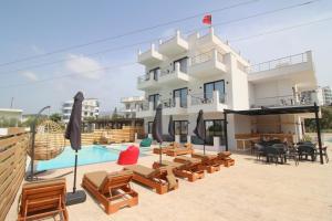 a resort with a pool and chairs and a building at Noa Boutique Hotel in Ksamil
