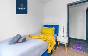 a bedroom with a bed with a yellow blanket on it at THE DENS, 3 Rooms, 4 Beds, 2 Bathrooms, Fully Equipped, Wifi, Parking, Mid-Long Stays Rates Available by SUNRISE SHORT LETS in Dundee