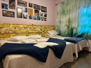two beds in a room with blue sheets at Pousada La na Roça in Paraisópolis