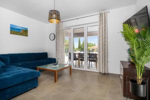 a living room with a blue couch and a table at Holiday Home Family Love in Labin