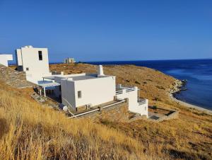 un grupo de edificios blancos en una colina cerca del océano en the South Breeze, en Caristo