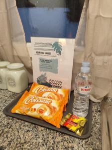 uma bandeja com um saco de batatas fritas e uma garrafa de água em Johnson house em Rafina