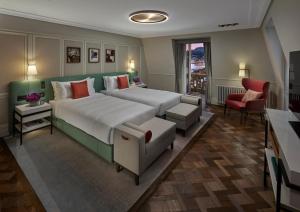 ein großes Schlafzimmer mit einem großen Bett und einem Stuhl in der Unterkunft Mandarin Oriental Palace, Luzern in Luzern