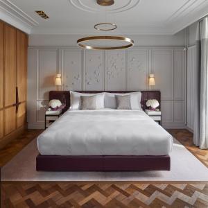 um quarto com uma grande cama branca e um lustre em Mandarin Oriental Palace, Luzern em Lucerna