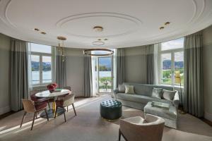 a living room with a couch and a table and chairs at Mandarin Oriental Palace, Luzern in Luzern