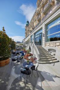 a patio with tables and chairs and a building at Mandarin Oriental Palace, Luzern in Lucerne