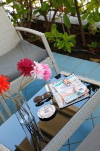 a table with a magazine on a chair with flowers at Settessenze Residence & Rooms in Agropoli