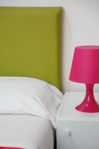 a red lamp on a night stand next to a bed at Settessenze Residence & Rooms in Agropoli