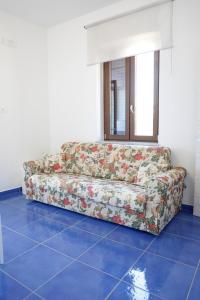 a couch sitting on a blue tile floor in a room at Settessenze Residence & Rooms in Agropoli