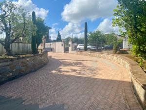 une promenade en briques avec une clôture et des arbres dans l'établissement -Casa Vacanza Il Glicine- Immerso Nel Verde, à Altopascio