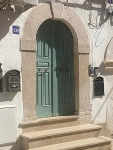 una porta verde in un edificio bianco con scale di Aduepassi apartments a Manfredonia