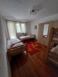 a bedroom with two beds and a living room at Apartman EL in Sarajevo