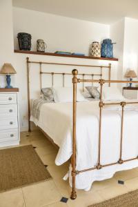 um quarto com uma cama de metal com lençóis brancos em Villa Dei Fiori em São Sebastião