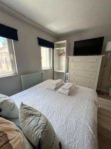 - une chambre avec un lit blanc et 2 oreillers dans l'établissement Charmoso estúdio perto da praia, à Parede