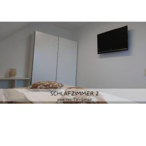 a room with a bed and a tv on a wall at Ferienwohnung Katzensprung Jonsdorf in Kurort Jonsdorf