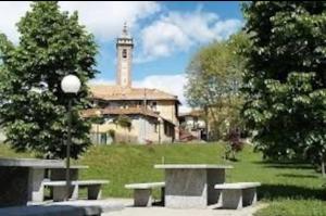 a building with a clock tower in a park with benches at Canton Pasquera in Agrano
