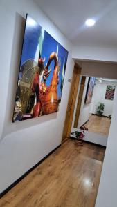 a hallway with a large painting on a wall at Yellow House in Manizales