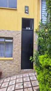 a black door on the side of a building at Yellow House in Manizales