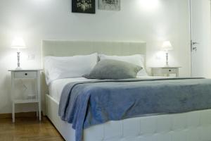 1 cama blanca con manta azul y 2 mesitas de noche en 3 Inn Ripetta, en Roma