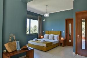 um quarto com uma cama com paredes azuis em Dalasvillas SkalaAcqua em Skála Kefalonias