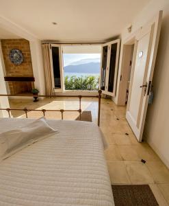1 dormitorio con cama y ventana grande en Villa Dei Fiori, en São Sebastião