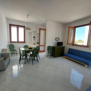 een woonkamer met een blauwe bank en een tafel en stoelen bij Casa Paco in Favignana