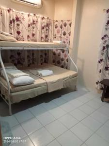 a small room with a bunk bed with curtains at Loidas place in Talisay