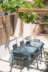 une table bleue et des chaises sur une terrasse dans l'établissement Le Cabanon - Les pieds dans l'eau - Calanques - Wifi, à Ensuès-la-Redonne