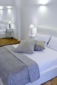 a white bedroom with a large white bed with pillows at 3 Inn Ripetta in Rome