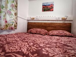 1 dormitorio con 1 cama con 2 almohadas en Barkóca és Szépkilátás Vendégház / Cabin en Kismaros