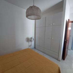 een slaapkamer met een bed, een lamp en een ventilator bij Casa Paco in Favignana