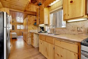 een keuken met houten kasten, een wastafel en een koelkast bij 2259-Fawnskin Pines cabin in Fawnskin