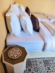 ein Bett mit vielen Kissen und einem Tablett darauf in der Unterkunft Zagora Oasis Lodge in Zagora