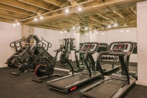 a gym with several cardio machines in a room at Sonder The Winfield in Los Angeles