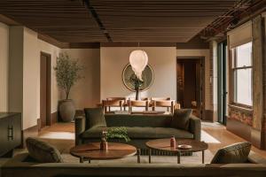 Sonder The Winfield في لوس أنجلوس: غرفة معيشة مع أريكة خضراء وطاولات