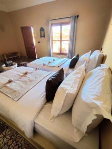 Zimmer mit 3 Betten und Kissen darauf in der Unterkunft Zagora Oasis Lodge in Zagora