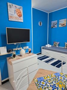 a living room with blue walls and a tv at Destinazione Mare Naxos in Giardini Naxos