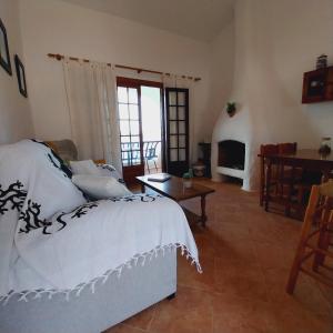 um quarto com uma cama, uma mesa e uma lareira em Apto POBLET by MENORCAHOST - Vistas únicas al mar en Playas de Fornells em Es Mercadal