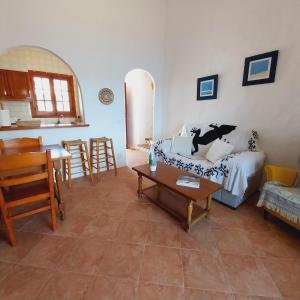 ein Wohnzimmer mit einem Sofa und einem Tisch in der Unterkunft Apto POBLET by MENORCAHOST - Vistas únicas al mar en Playas de Fornells in Es Mercadal