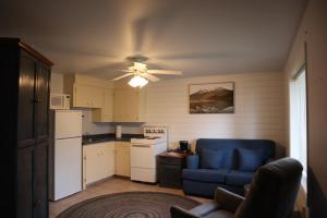 a kitchen with a blue couch and a ceiling fan at Blue Shore Resort in Savona