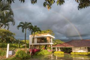 einen Regenbogen über einem Gebäude mit Garten in der Unterkunft Chalet La Alemania in Calarcá