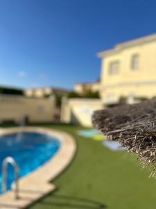 zbliżenie basenu i domu w obiekcie Bungalow Aguas Nuevas Costa del Cezar w mieście Torrevieja