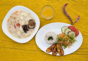 - une table avec deux assiettes de nourriture et un bol de soupe dans l'établissement Hostal La Mariapolis, à Necoclí