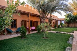 una casa con una palmera en el patio en Le Palais Averroes - Adults Only en Marrakech