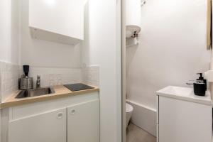 a white bathroom with a sink and a toilet at Les nuits d’Ina in Toulon