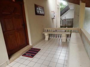 a hallway with a door and a bench on a tiled floor at Mallika Guest House in Hikkaduwa +37 photos